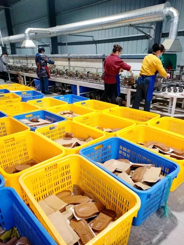 zapatillashombre.com: Línea de montaje de suelas en una de las fábricas de la alianza: cestas con suelas y plantillas listas para unir